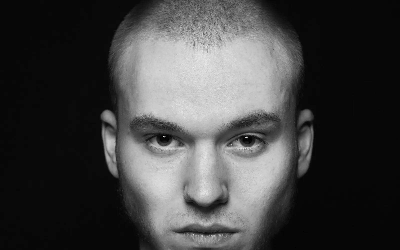 Black and white portrait of a young man looking straight at the camera